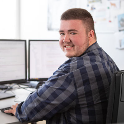 Ein dualer Student für Informatik programmiert an seinem Computer 