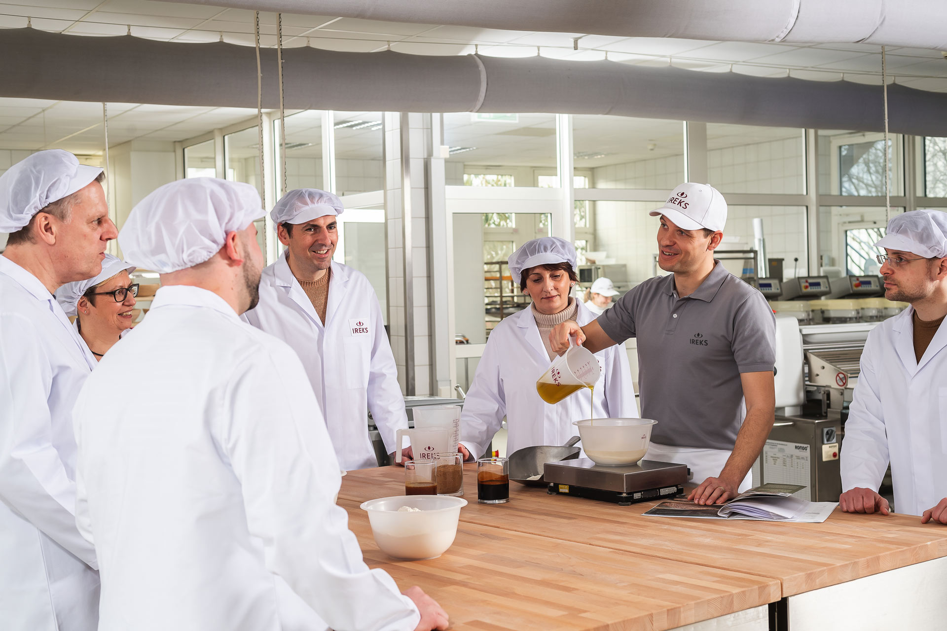 Bäcker zeigt einer Gruppe eine Teigzusammensetzung in der Bäckerei